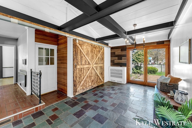405 S 1st St, Edmore, MI 48829 - interior space featuring wooden walls, a barn door, beam ceiling, and radiator heating unit