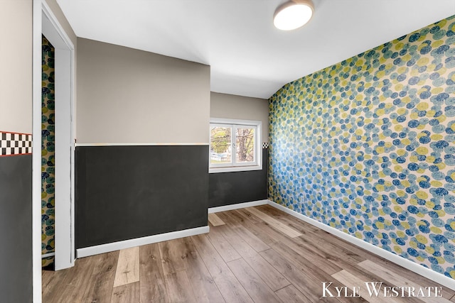405 S 1st St, Edmore, MI 48829 - unfurnished room featuring wallpapered walls, wood finished floors, baseboards, and an accent wall