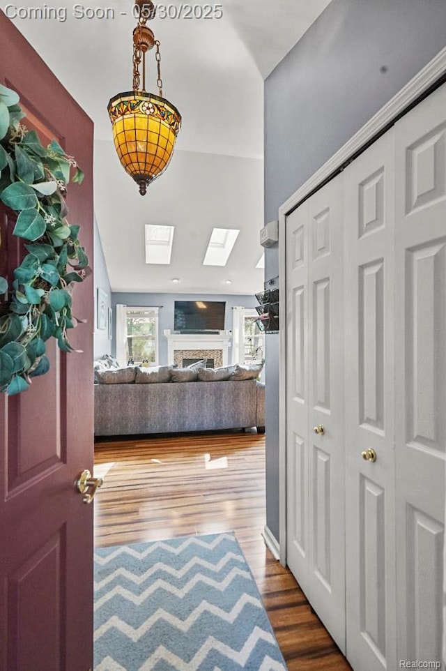 9450 Sandlewood Ct, Whitmore Lake, MI 48189 - foyer entrance featuring a skylight, wood finished floors, and a fireplace