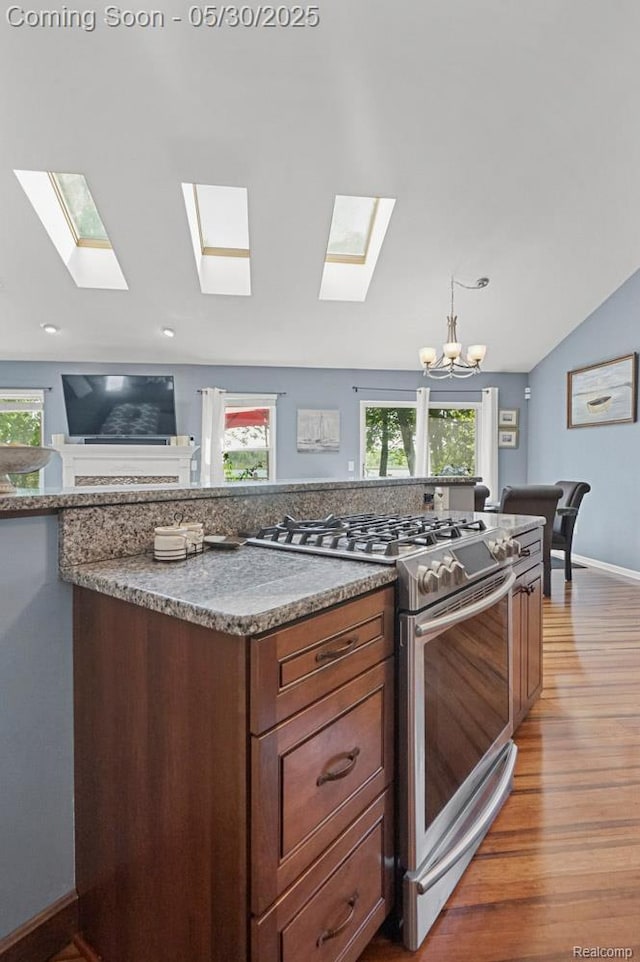 9450 Sandlewood Ct, Whitmore Lake, MI 48189 - kitchen featuring gas range, a skylight, a chandelier, light wood-type flooring, and vaulted ceiling