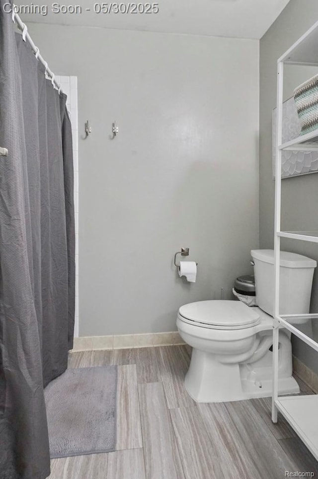 9450 Sandlewood Ct, Whitmore Lake, MI 48189 - full bath featuring toilet, wood finished floors, a shower with curtain, and baseboards