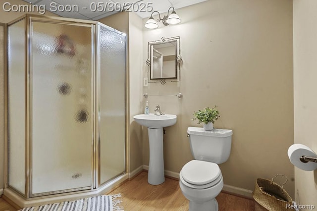 9450 Sandlewood Ct, Whitmore Lake, MI 48189 - full bathroom featuring wood finished floors, a stall shower, toilet, and baseboards