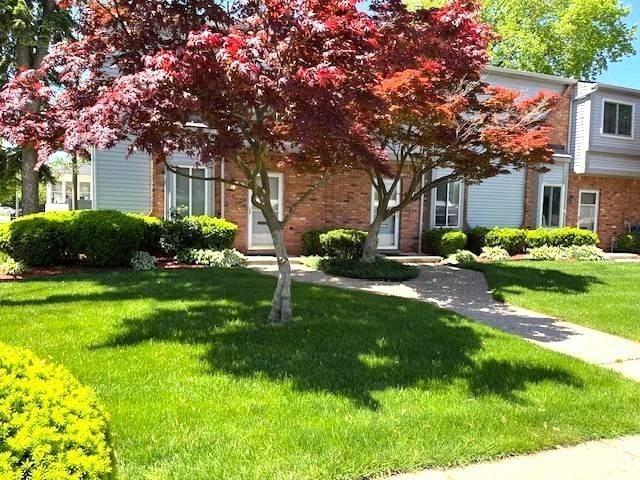48 Council Ave Unit A, Clawson, MI 48017 - view of property hidden behind natural elements featuring a front lawn and brick siding