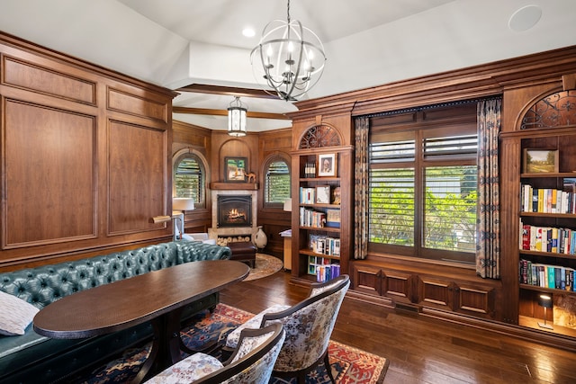 home office featuring a chandelier, dark wood-style flooring, a lit fireplace, and high vaulted ceiling