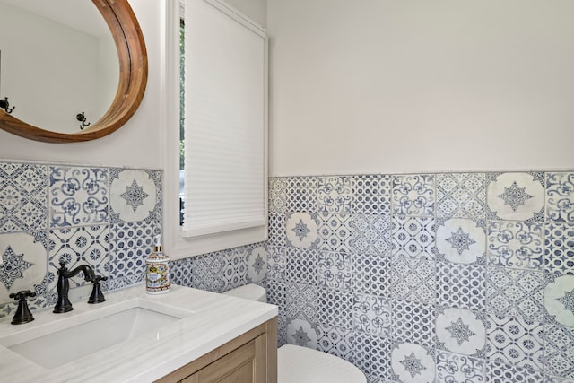 bathroom featuring tile walls, vanity, and toilet