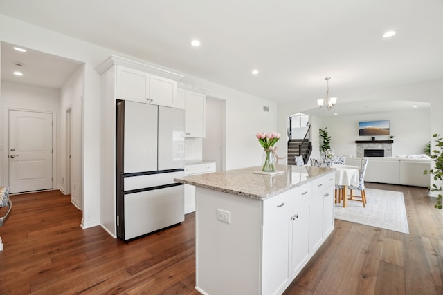49793 Split Rock Rd, Macomb, MI 48044 - kitchen featuring freestanding refrigerator, white cabinetry, dark wood-style flooring, light stone countertops, and a center island