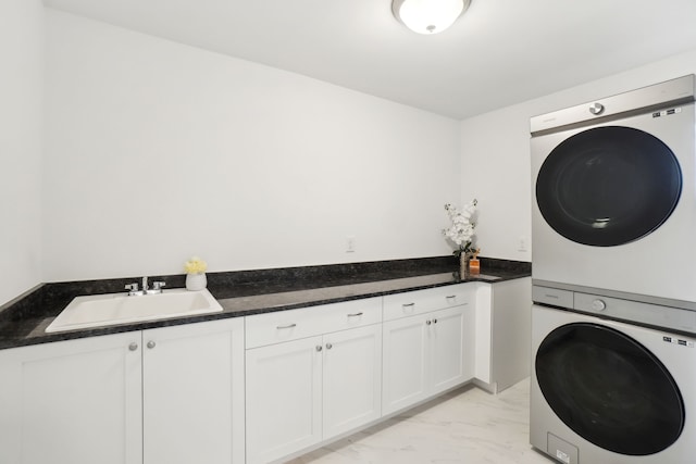 49793 Split Rock Rd, Macomb, MI 48044 - laundry area with stacked washer and clothes dryer, light marble finish floors, and cabinet space