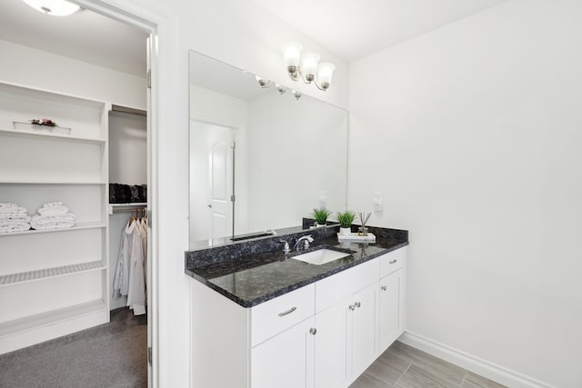 49793 Split Rock Rd, Macomb, MI 48044 - bathroom featuring a spacious closet, baseboards, and vanity