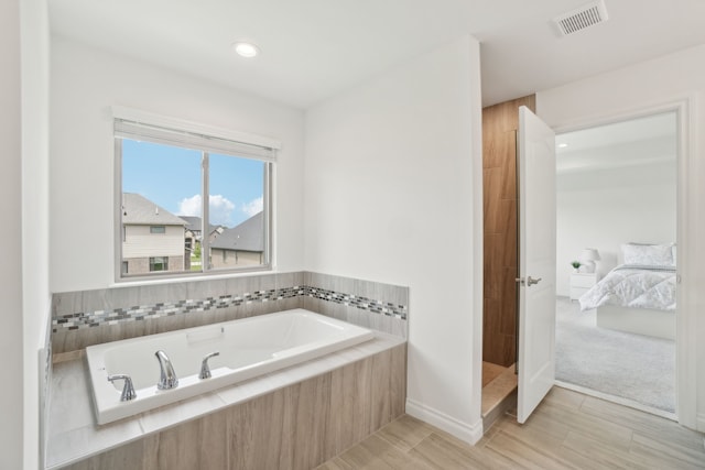 49793 Split Rock Rd, Macomb, MI 48044 - bathroom with ensuite bathroom, a bath, baseboards, wood finished floors, and recessed lighting
