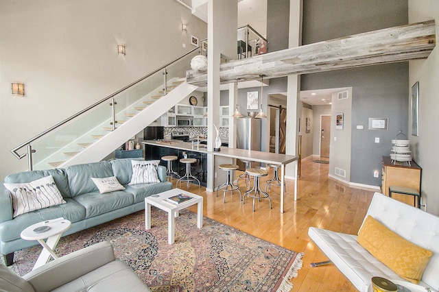 101 W Liberty St Unit 320, Ann Arbor, MI 48104 - living area featuring stairway, hardwood / wood-style flooring, a towering ceiling, and baseboards