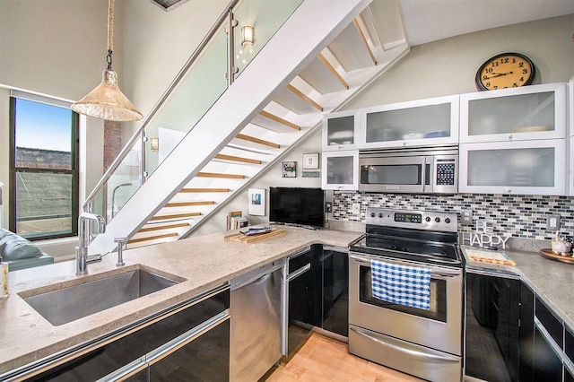 101 W Liberty St Unit 320, Ann Arbor, MI 48104 - kitchen with appliances with stainless steel finishes, a sink, light stone countertops, and backsplash