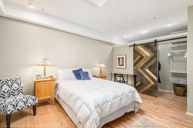 101 W Liberty St Unit 320, Ann Arbor, MI 48104 - bedroom with light wood-style flooring, a barn door, baseboards, and recessed lighting