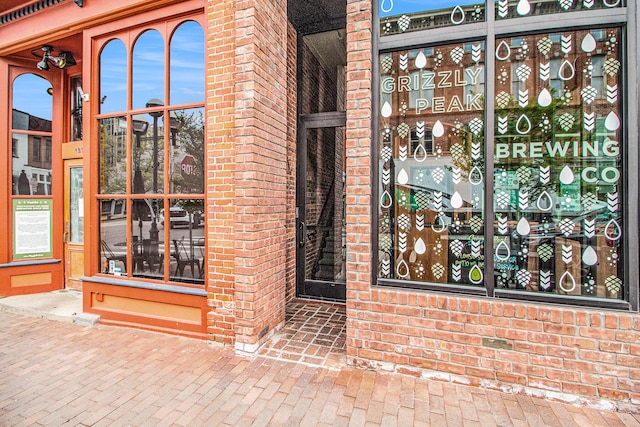 view of exterior entry with brick siding