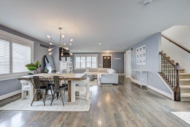 dining room featuring stairway, wood finished floors, baseboards, a chandelier, and recessed lighting