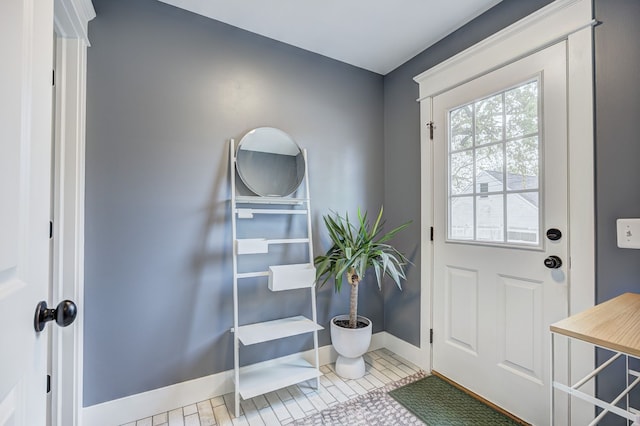 doorway to outside featuring baseboards and tile patterned floors