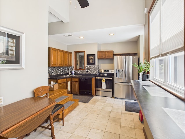 480 Peninsula Dr, Columbiaville, MI 48421 - kitchen with appliances with stainless steel finishes, dark countertops, brown cabinets, decorative backsplash, and recessed lighting