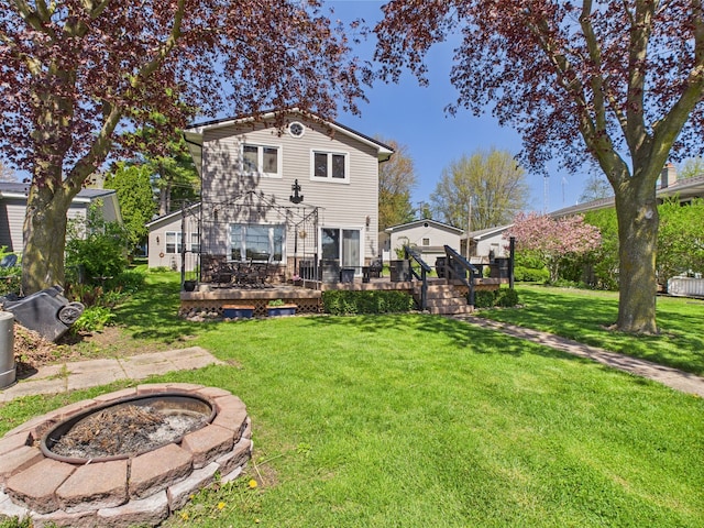 480 Peninsula Dr, Columbiaville, MI 48421 - rear view of property featuring a fire pit, a deck, and a lawn