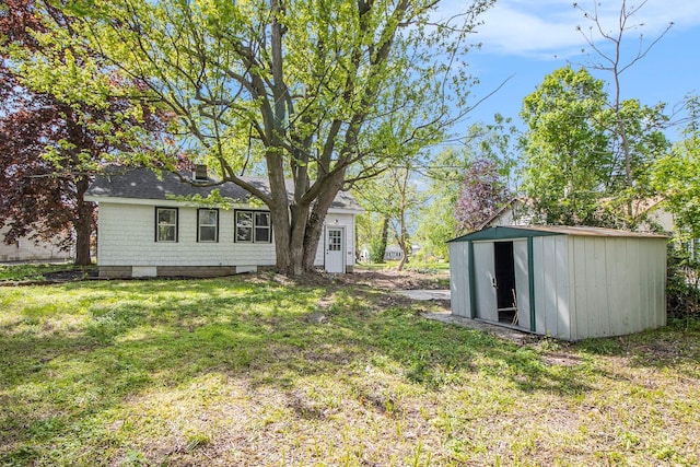 view of grassy yard with a storage shed and an outdoor structure