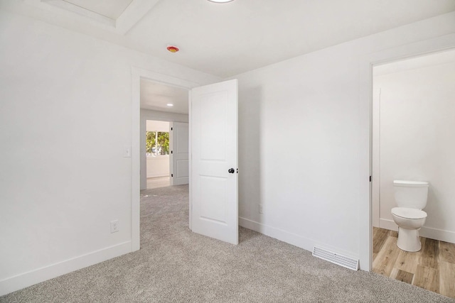 unfurnished bedroom with baseboards and light carpet