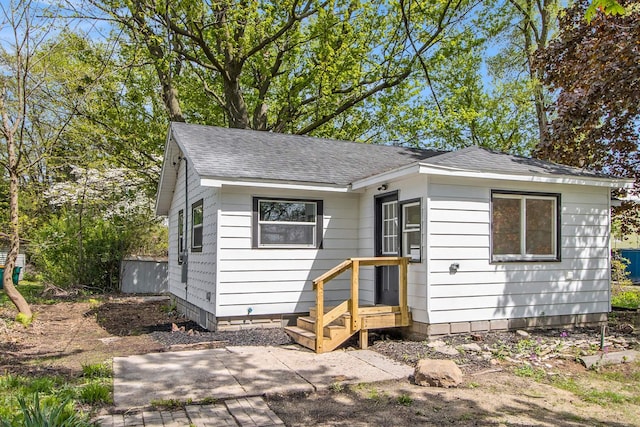 view of front of house featuring a shingled roof and a patio