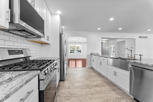 1132 Superior Blvd, Wyandotte, MI 48192 - kitchen with stainless steel appliances, a sink, tasteful backsplash, recessed lighting, and light stone counters