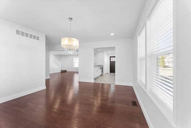 1132 Superior Blvd, Wyandotte, MI 48192 - unfurnished dining area featuring wood finished floors, a chandelier, stairway, baseboards, and recessed lighting