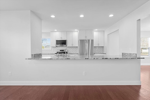 1132 Superior Blvd, Wyandotte, MI 48192 - kitchen featuring stainless steel appliances, a peninsula, light stone countertops, wood finished floors, and recessed lighting