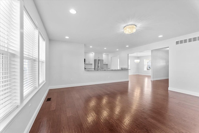 1132 Superior Blvd, Wyandotte, MI 48192 - unfurnished living room featuring wood finished floors, recessed lighting, baseboards, and a chandelier