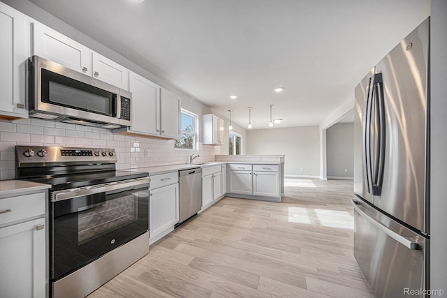 735 Lone Oak Way, Tecumseh, MI 49286 - kitchen featuring stainless steel appliances, a peninsula, light countertops, tasteful backsplash, and recessed lighting