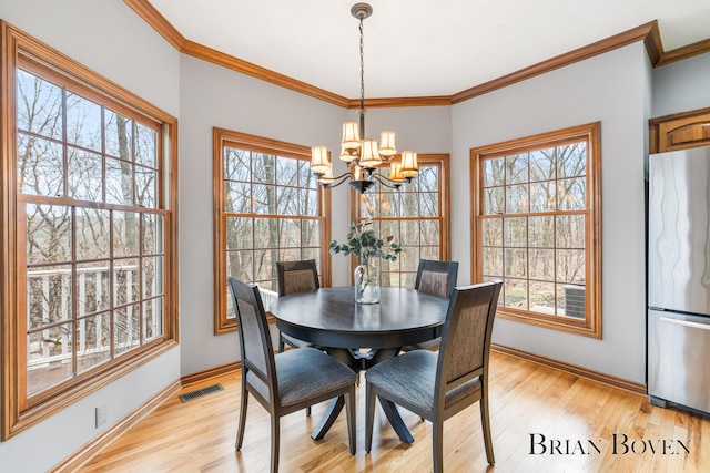 7620 Spring Point Ct NE, Rockford, MI 49341 - dining space with a chandelier, baseboards, light wood-style floors, and ornamental molding