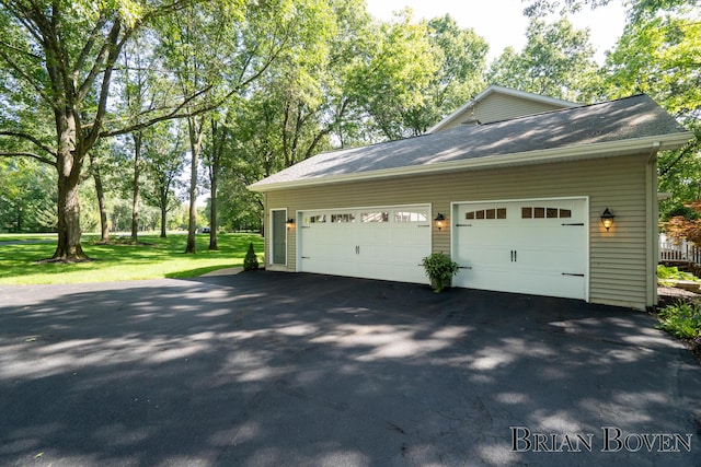 7620 Spring Point Ct NE, Rockford, MI 49341 - garage featuring asphalt driveway and view of scattered trees