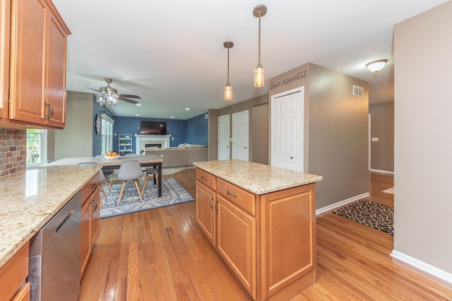 661 Morning Glory Ln, Milan, MI 48160 - kitchen featuring dishwasher, a fireplace, a ceiling fan, light wood-style flooring, and hanging light fixtures