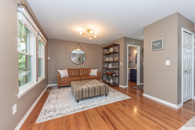 661 Morning Glory Ln, Milan, MI 48160 - living area featuring light wood-style flooring, baseboards, and a chandelier