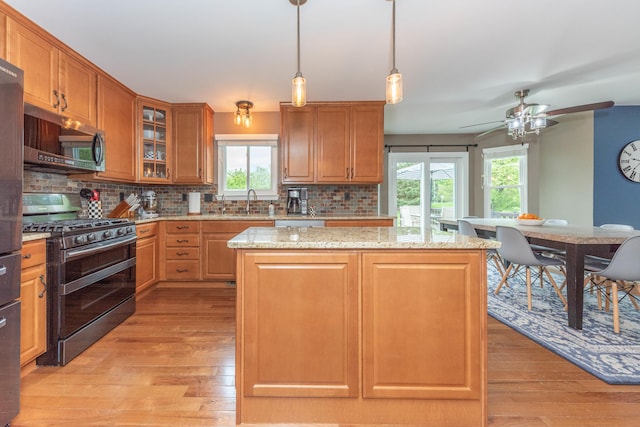 661 Morning Glory Ln, Milan, MI 48160 - kitchen featuring appliances with stainless steel finishes, backsplash, light wood-type flooring, and a kitchen island