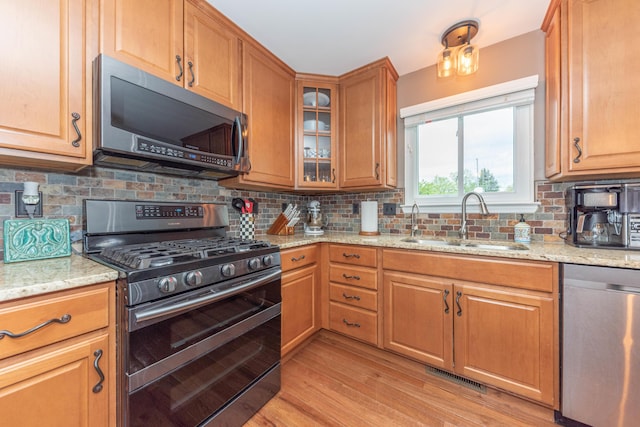661 Morning Glory Ln, Milan, MI 48160 - kitchen featuring appliances with stainless steel finishes, a sink, light stone countertops, tasteful backsplash, and light wood finished floors