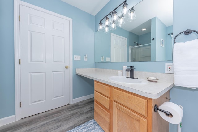 661 Morning Glory Ln, Milan, MI 48160 - bathroom featuring wood finished floors, a shower with shower door, vanity, and baseboards