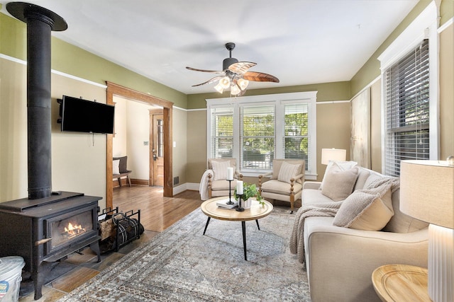 721 W Washington St, Ann Arbor, MI 48103 - living area featuring a wood stove, a ceiling fan, wood finished floors, and baseboards