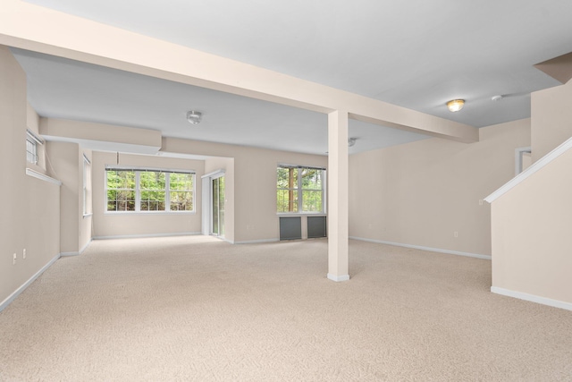 unfurnished living room with carpet flooring and baseboards