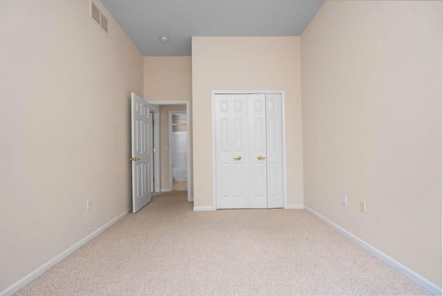 unfurnished bedroom featuring light colored carpet, baseboards, and a closet