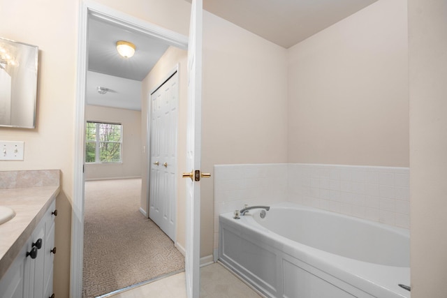 bathroom featuring vanity, a bath, and baseboards