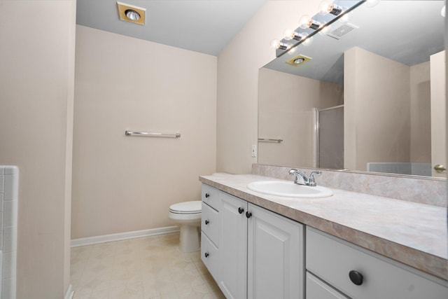 bathroom with a shower with door, vanity, toilet, and baseboards