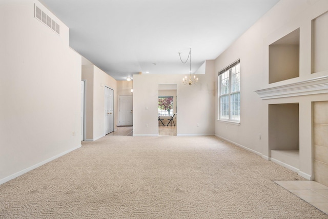 unfurnished living room with a chandelier, light carpet, and baseboards
