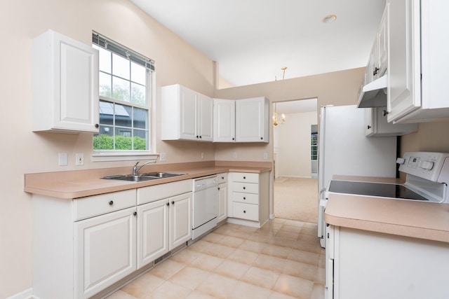 kitchen featuring white dishwasher, a sink, under cabinet range hood, white cabinets, and a chandelier