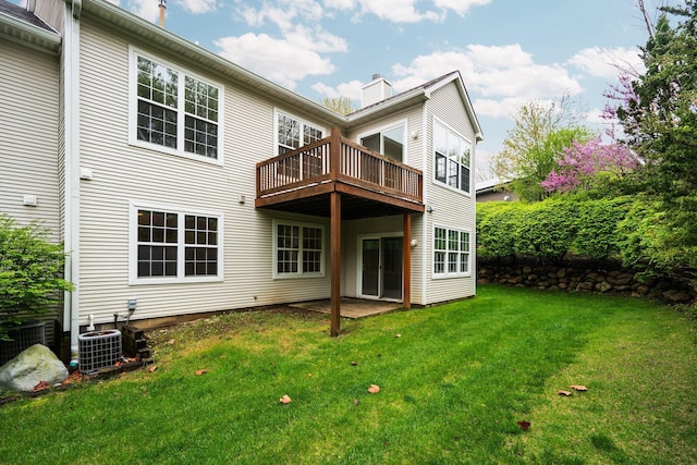 back of property with a lawn, a chimney, and central air condition unit