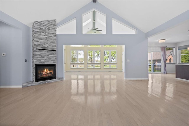 12150 Shaffer Rd, Davisburg, MI 48350 - unfurnished living room featuring ceiling fan, a fireplace, high vaulted ceiling, light wood-type flooring, and baseboards