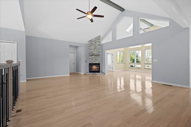 12150 Shaffer Rd, Davisburg, MI 48350 - unfurnished living room with high vaulted ceiling, a ceiling fan, beam ceiling, a fireplace, and light wood-type flooring