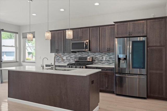 12150 Shaffer Rd, Davisburg, MI 48350 - kitchen with stainless steel appliances, a sink, light wood-type flooring, light countertops, and dark brown cabinetry