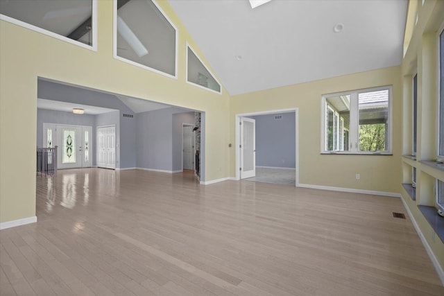 12150 Shaffer Rd, Davisburg, MI 48350 - unfurnished living room with high vaulted ceiling, healthy amount of natural light, wood finished floors, and baseboards