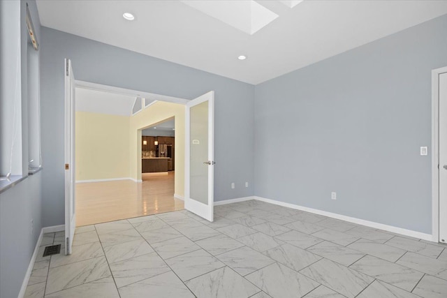 12150 Shaffer Rd, Davisburg, MI 48350 - spare room featuring a skylight, light marble finish floors, baseboards, and recessed lighting
