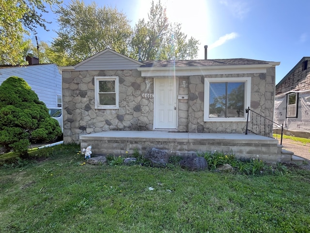 bungalow with stone siding, a front lawn, and a porch